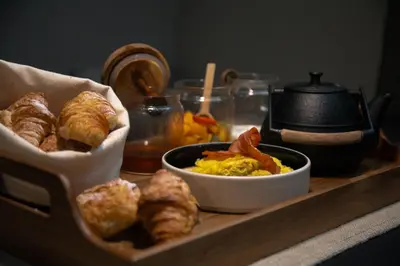 a tray of food with bread and eggs and croissants at The Sanctuary Urban Retreat in Rome