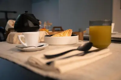 a table with a plate of food and a glass of orange juice at The Sanctuary Urban Retreat in Rome
