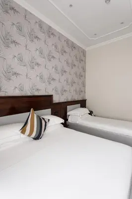 two twin beds in a room with a wall at Esposizione Boutique in Rome