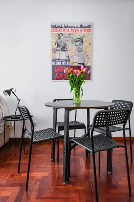 a table and chairs with a vase of flowers on it at St. Peter Vatican Home in Rome