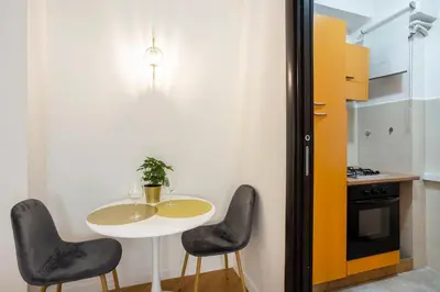 a small kitchen with a table and two chairs at Re di Roma - Charme Apartment in Rome