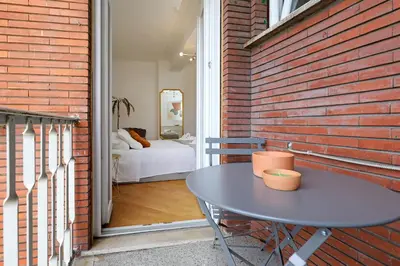 a patio with a table and a brick wall at Re di Roma - Charme Apartment in Rome