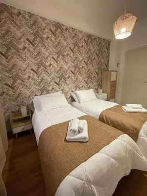 a hotel room with two beds with towels on them at Gregorio VII Vatican House in Rome