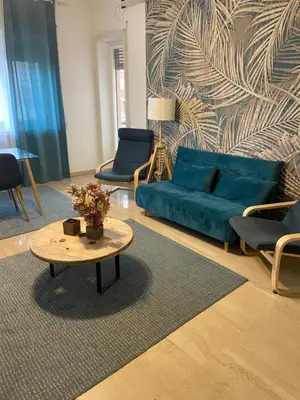a living room with a blue couch and a table at Gregorio VII Vatican House in Rome