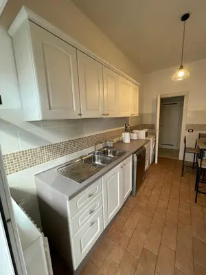 a kitchen with white cabinets and a sink at Gregorio VII Vatican House in Rome