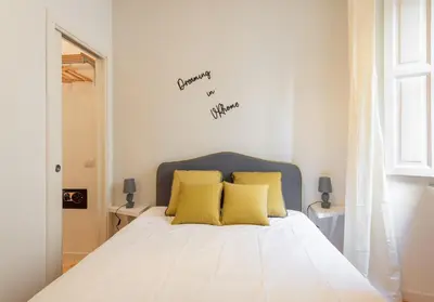 a bedroom with a white bed with yellow pillows at VRhome in Rome