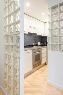 a kitchen with white cabinets and a glass wine cellar at VRhome in Rome