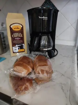 two sandwiches in plastic bags on a counter with a coffee maker at Home in Trastevere Testaccio in Rome
