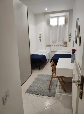 a room with two beds and a table and a mirror at Home in Trastevere Testaccio in Rome