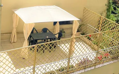 a table and chairs under an umbrella on a balcony at ZAMA HOME in Rome