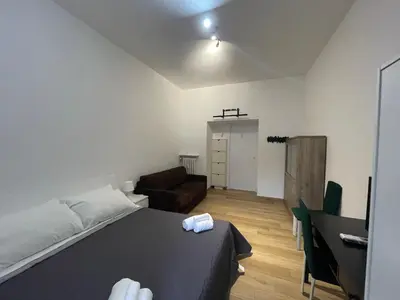 a bedroom with a bed and a couch and a desk at ZAMA HOME in Rome
