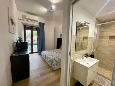 a bathroom with a bed and a sink and a mirror at ZAMA HOME in Rome