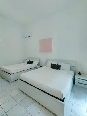 a bedroom with two beds and a table with lamps at Bosuites Rome in Rome