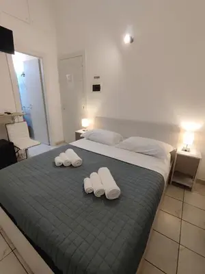 a bedroom with a bed with two slippers on it at Bosuites Rome in Rome