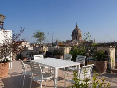 a white table and chairs on a patio at Terrace Apartment On The Monuments Of Rome in Rome