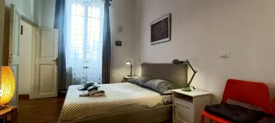 a bedroom with a bed and a chair and a window at Terrace Apartment On The Monuments Of Rome in Rome