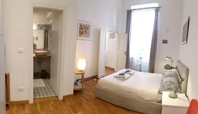a small bedroom with a bed and a mirror at Terrace Apartment On The Monuments Of Rome in Rome