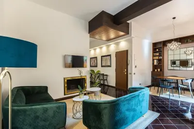 a living room with blue chairs and a fireplace at Borgo Terrace by Rental in Rome in Rome