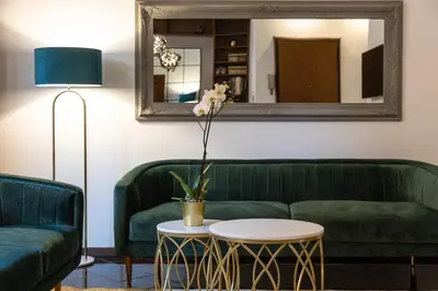 a living room with a green couch and a mirror at Borgo Terrace by Rental in Rome in Rome