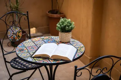 a table with a book and a potted plant on it at Borgo Terrace by Rental in Rome in Rome