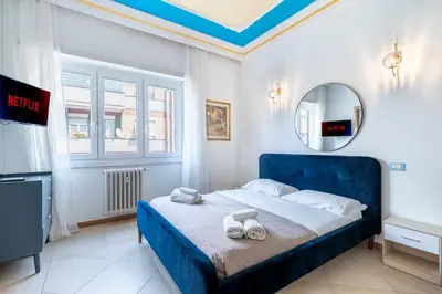 a bedroom with a blue bed and a mirror at Gregorio VII - Deliziosa sistemazione a due passi da San Pietro in Rome