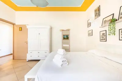 a bedroom with a white bed and a yellow ceiling at Gregorio VII - Deliziosa sistemazione a due passi da San Pietro in Rome