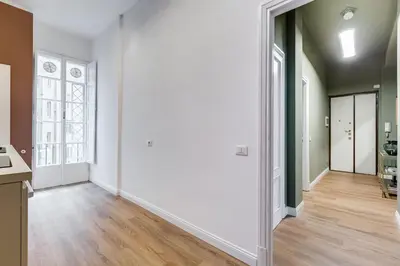 an empty living room with white walls and wood floors at Flaminio Lovely House in Rome
