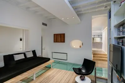 a living room with a black couch and a chair at Trevi Loft in Rome