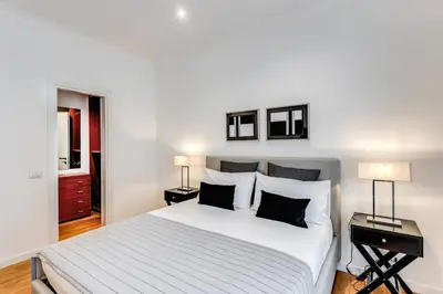a bedroom with a large white bed with two lamps at Charming flat by the Vatican in Rome