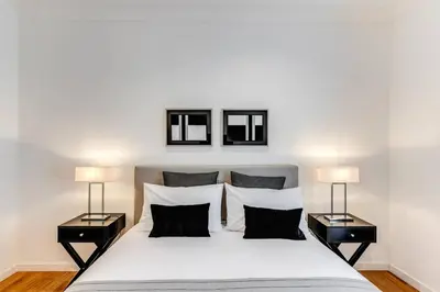 a bedroom with a large white bed with two lamps at Charming flat by the Vatican in Rome