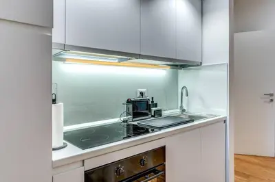a kitchen with white cabinets and a sink at Charming flat by the Vatican in Rome