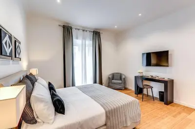 a bedroom with a bed and a desk and a television at Charming flat by the Vatican in Rome