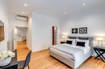 a white bedroom with a bed and a desk at Charming flat by the Vatican in Rome