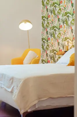 a bedroom with a bed and a yellow chair at Alloggio Re di Roma 43 in Rome