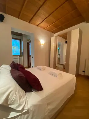 a bedroom with a large white bed with red pillows at sweet home Laurina in Rome