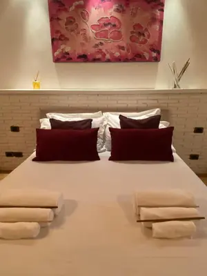 a large bed with three pillows on top of it at sweet home Laurina in Rome