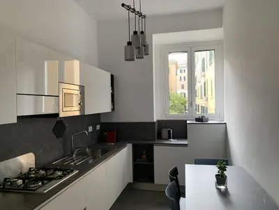 a kitchen with white cabinets and a counter top at Nox Romana Apartments - Vatican - Threeroom Apt with 2 Bathroom in Rome