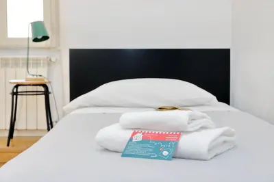 a white bed with towels on top of it at Vatican Spacious Modì Apartment in Rome