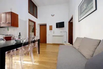 a kitchen and living room with a couch and a table at Vatican Spacious Modì Apartment in Rome