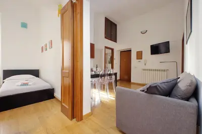 a living room with a couch and a dining room at Vatican Spacious Modì Apartment in Rome