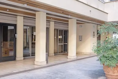 a building with columns and a plant in a pot at Modern Apartment at San Giovanni in Rome