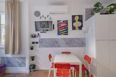 a dining room with a white table and red chairs at Modern Apartment at San Giovanni in Rome