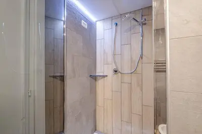 a bathroom with a shower with a glass door at Modern Apartment at San Giovanni in Rome