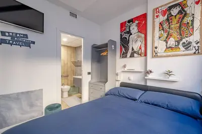 a bedroom with a blue bed and posters on the wall at Modern Apartment at San Giovanni in Rome