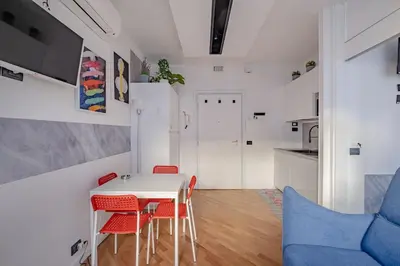 a dining room with a white table and red chairs at Modern Apartment at San Giovanni in Rome
