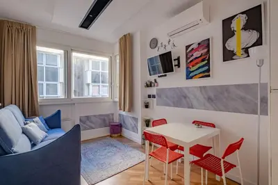 a living room with a table and red chairs at Modern Apartment at San Giovanni in Rome