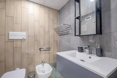 a bathroom with a white sink and a toilet at Modern Apartment at San Giovanni in Rome