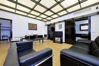 a living room with black leather furniture and a table at 4BNB - Spacious Porta Pia Apartment in Rome