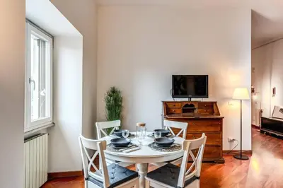 a dining room with a table and chairs and a television at Splendid flat on the Tiber river in Rome