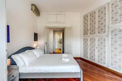 a bedroom with a white bed in a room at Splendid flat on the Tiber river in Rome